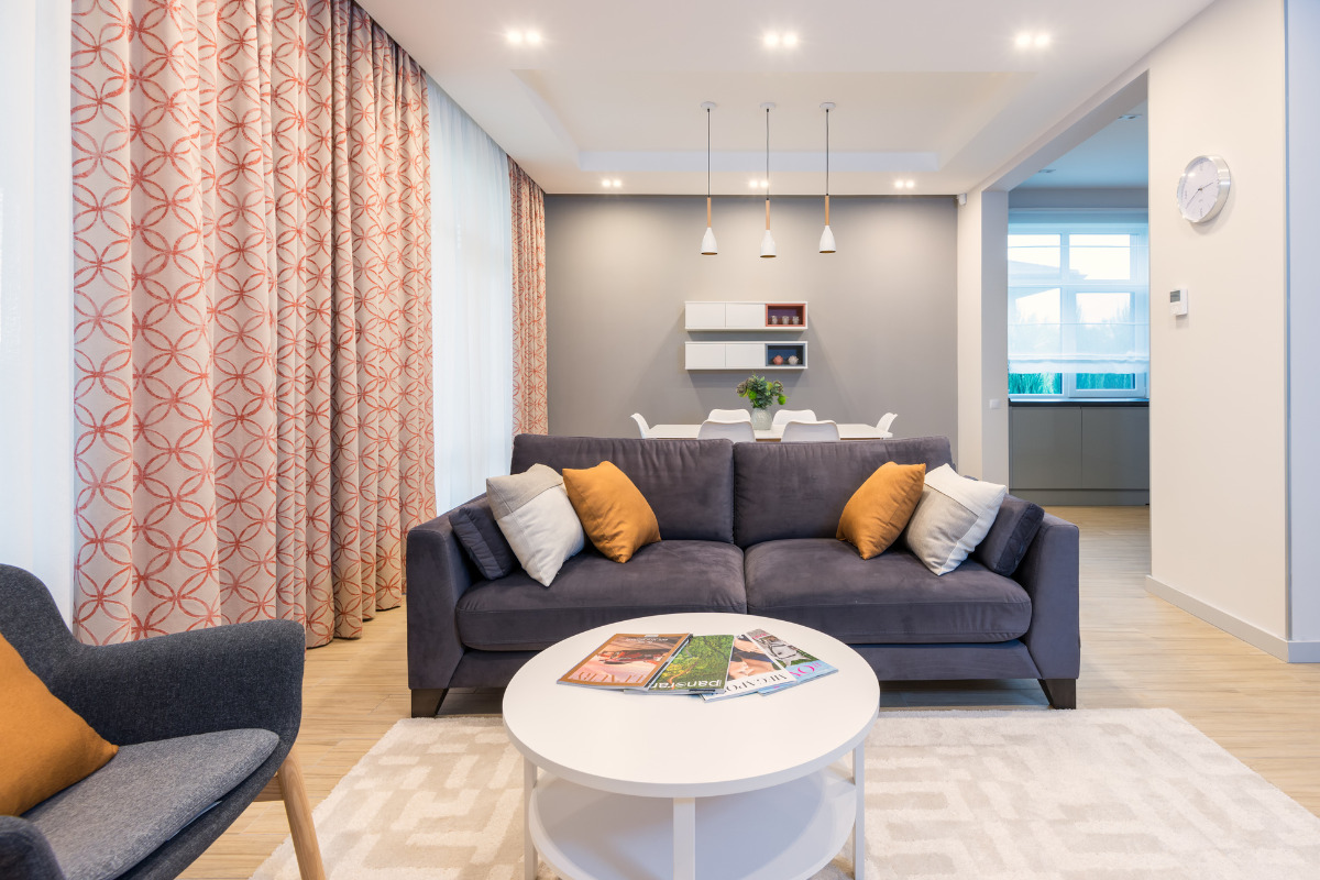 sala de apartamento com sofá, mesa e decoração. Imagem ilustrativa para texto quanto custa mobiliar um apartamento.