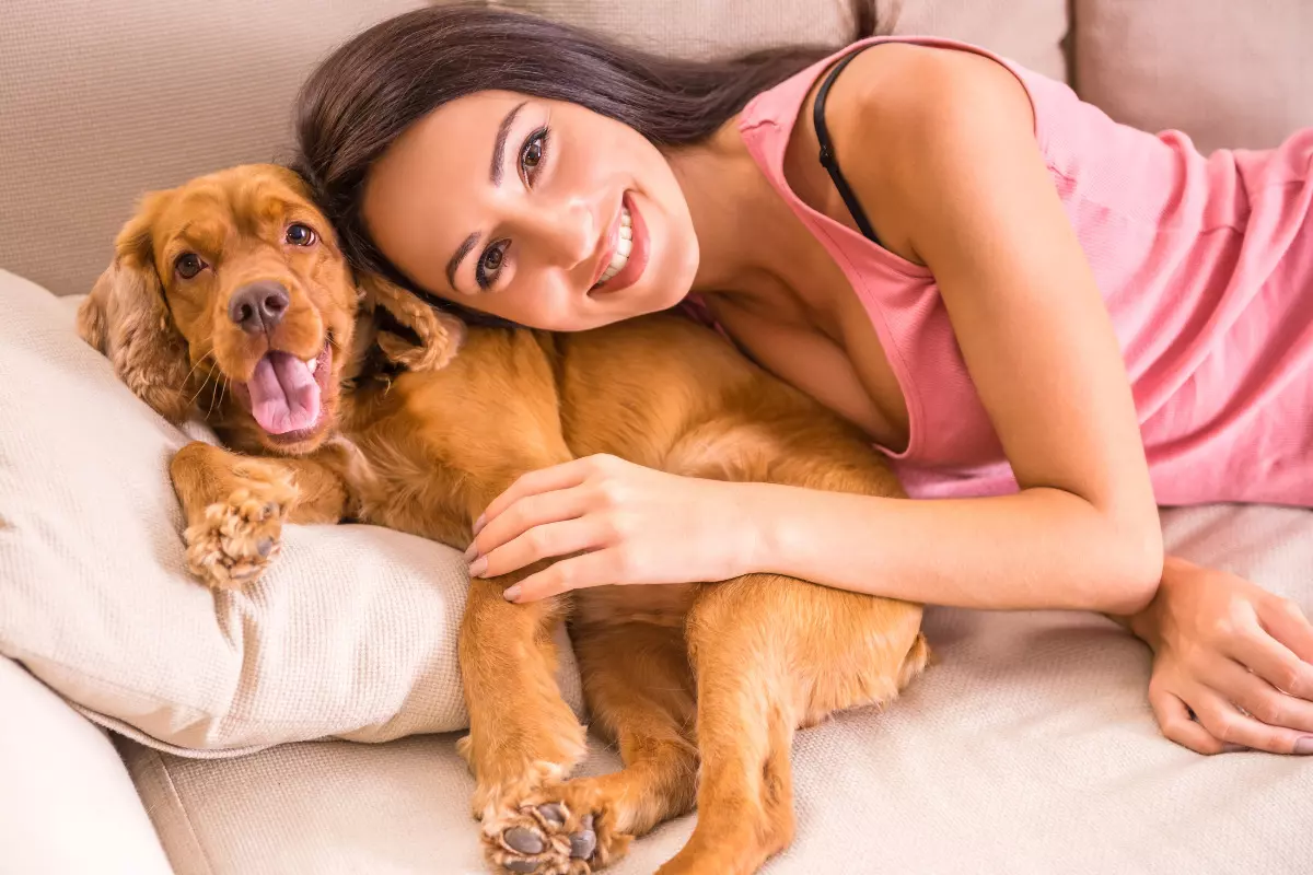 Moça e cachorro deitados em sofá. Imagem ilustrativa para texto cachorro para apartamento.