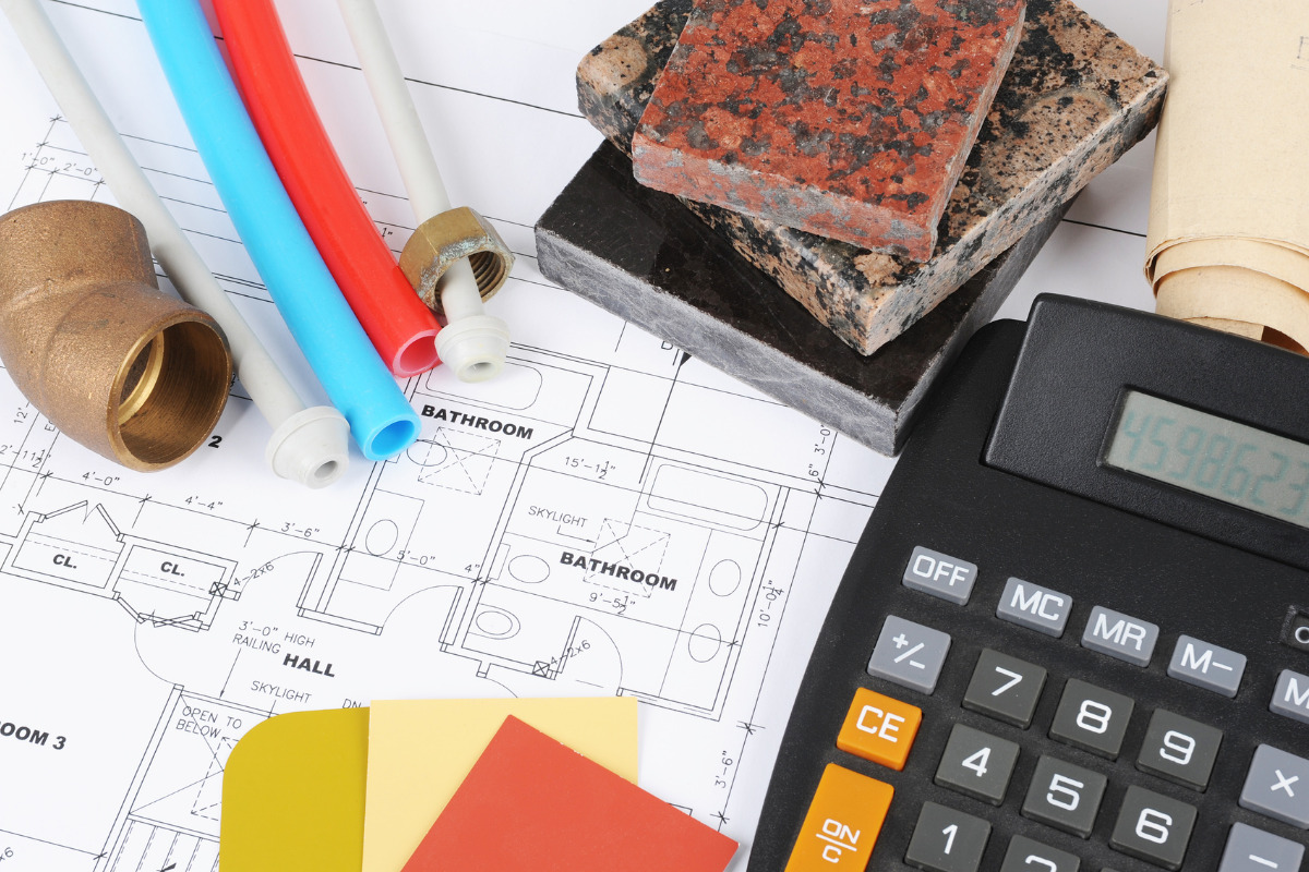 Materiais, planta e calculadora. Imagem ilustrativa para texto reformar banheiro gastando pouco.