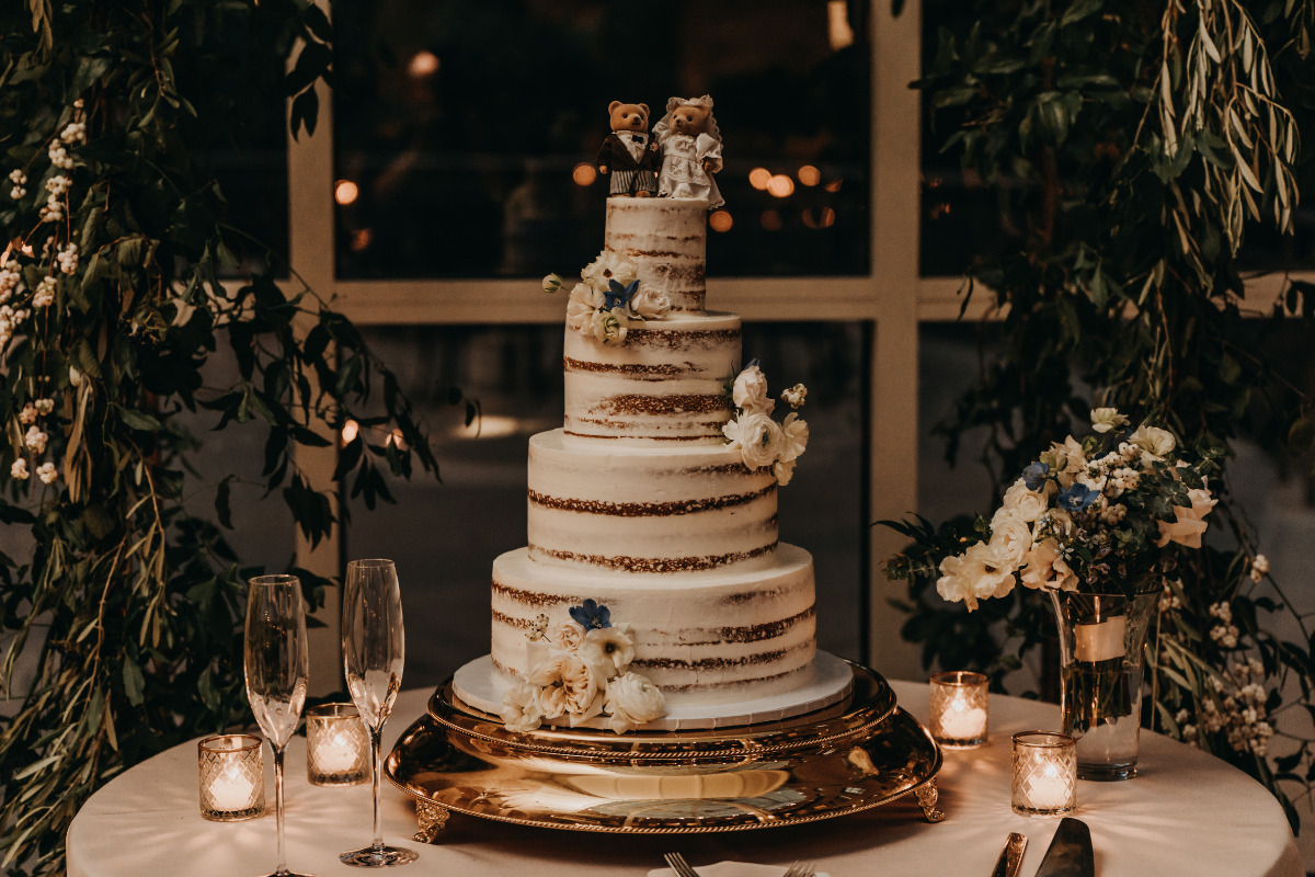bolo de casamento em estilo naked cake com quatro andares e enfeites.