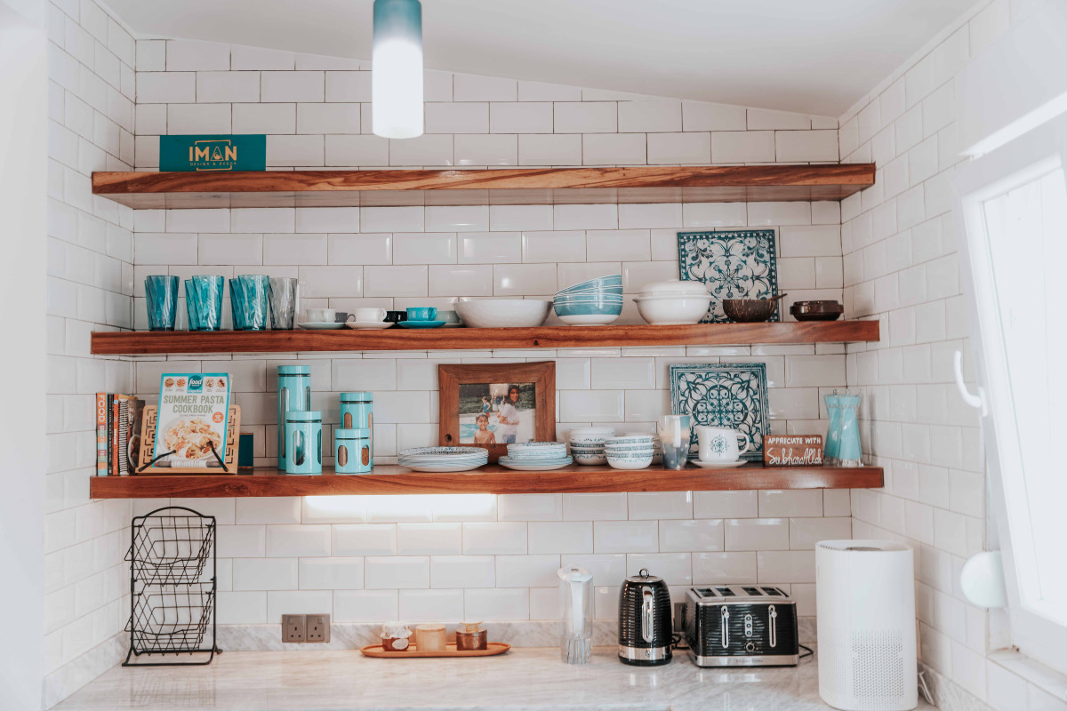 Saiba como utilizar quadros decorativos e trazer um charme ao ambiente parede de cozinha com prateleiras, quadros e utensílios.