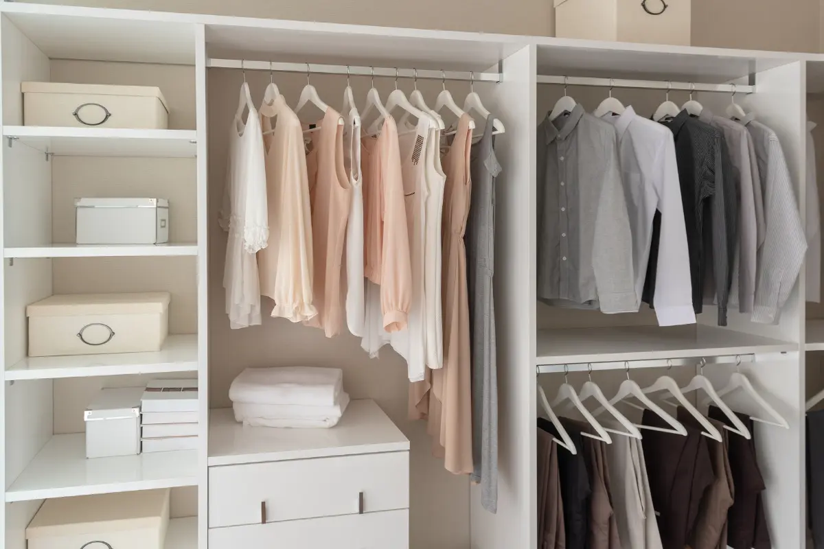 Como organizar guarda-roupa? Confira dicas simples! Peças bem organizadas em armário com cores separadas. Imagem ilustrativa para texto como organizar guarda-roupa.