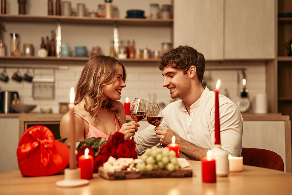 Amor em cada detalhe: dicas de decoração para o Dia dos Namorados Casal jantando em uma mesa com decoração para o Dia dos Namorados