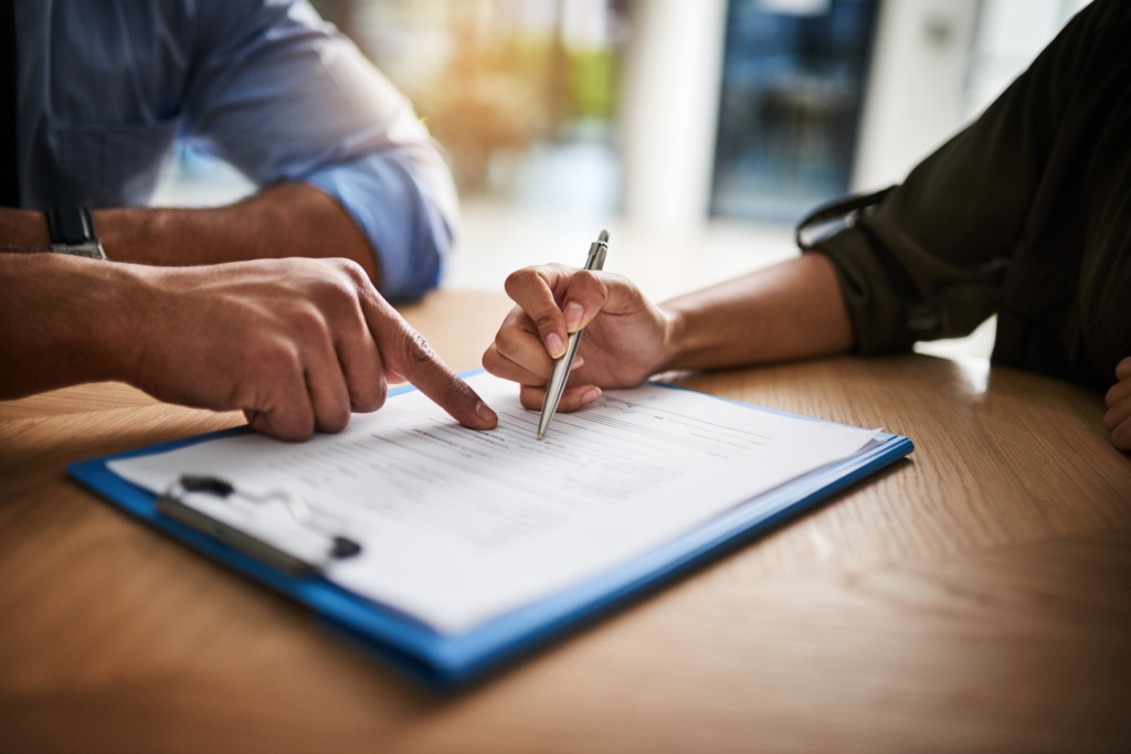Distrato imobiliário: entenda o que é, como funciona e quais são seus direitos Pessoa assinando o distrato imobiliário