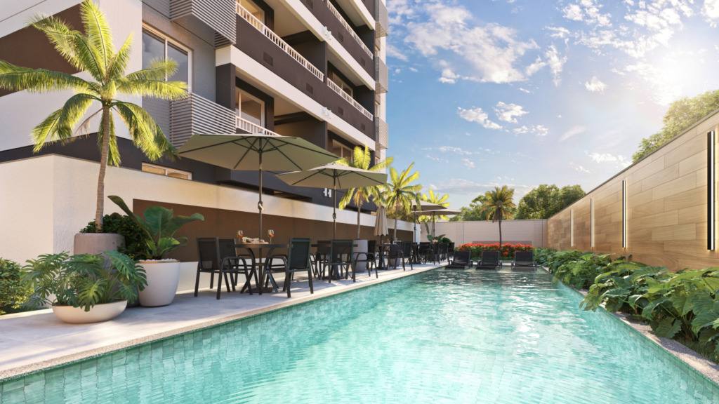 Como avaliar o custo-benefício de um apartamento? Dicas Piscina do Terrasse Vila Ema, empreendimento da Direcional em São Paulo/SP, com mesas e cadeiras sob guarda-sóis no deck, espreguiçadeiras ao fundo, palmeiras e jardim tropical ao lado do prédio residencial.